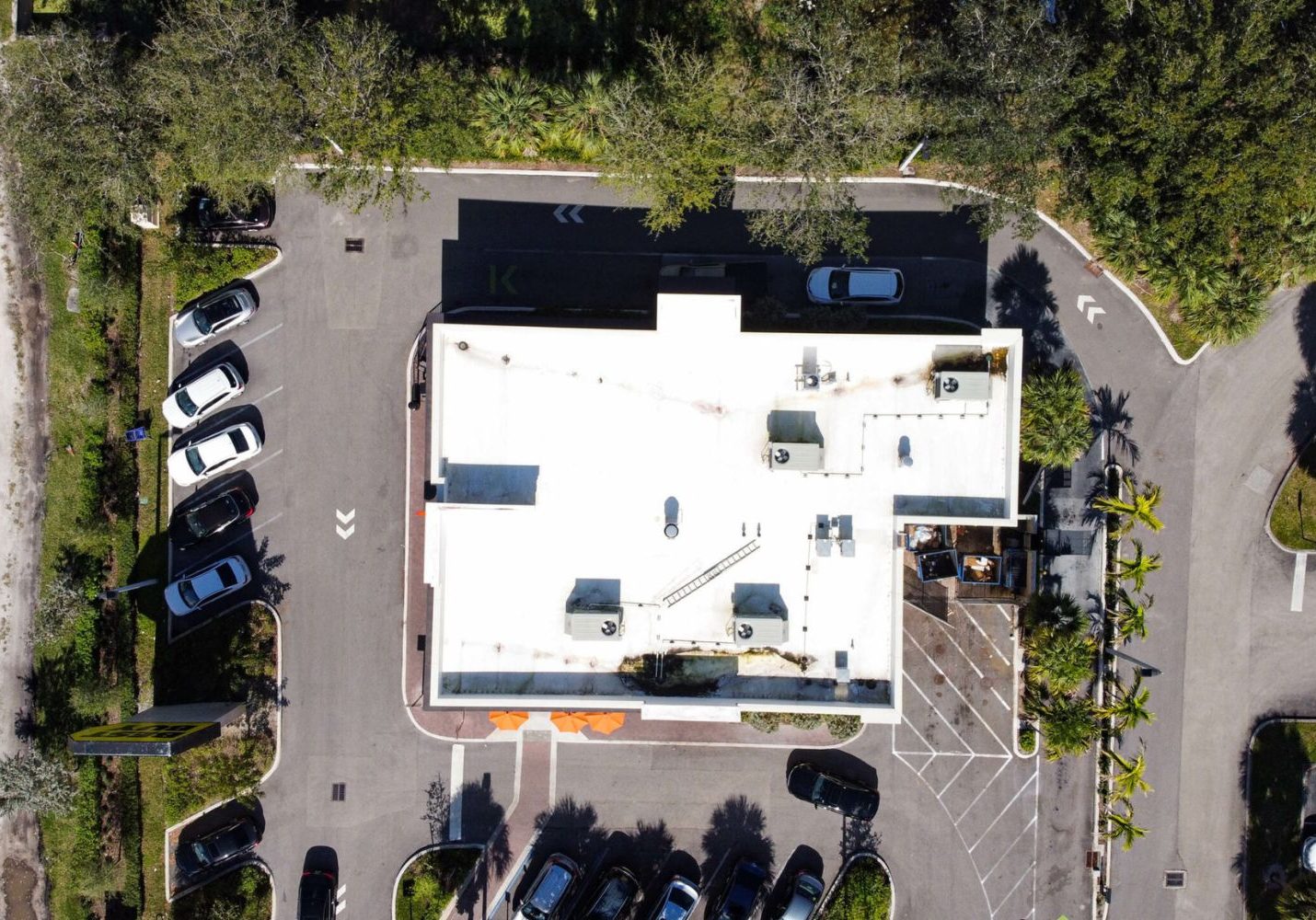 Overhead view of a commercial tile roof with adjacent pavement and landscaping