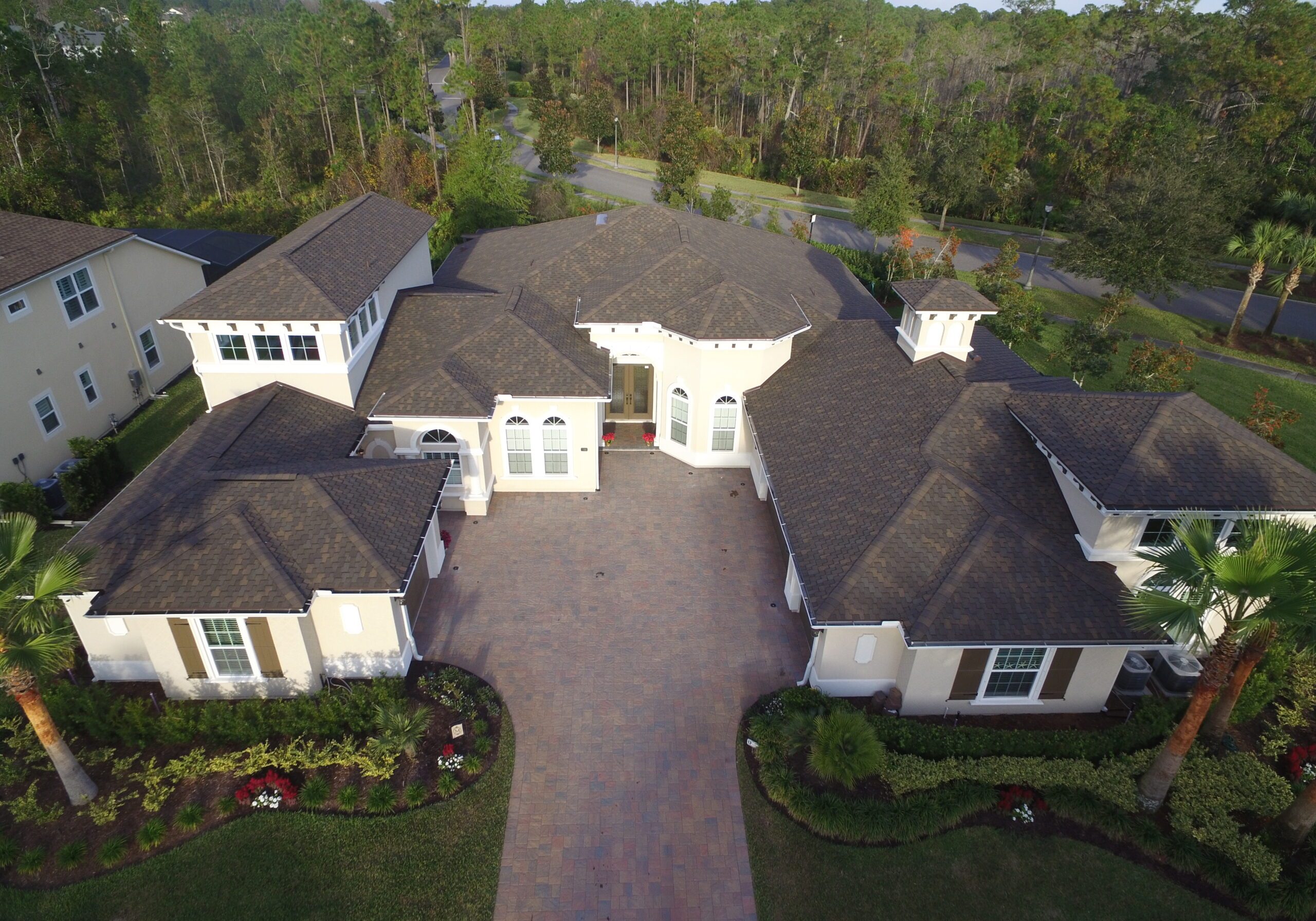 Large dark shingle roof white home