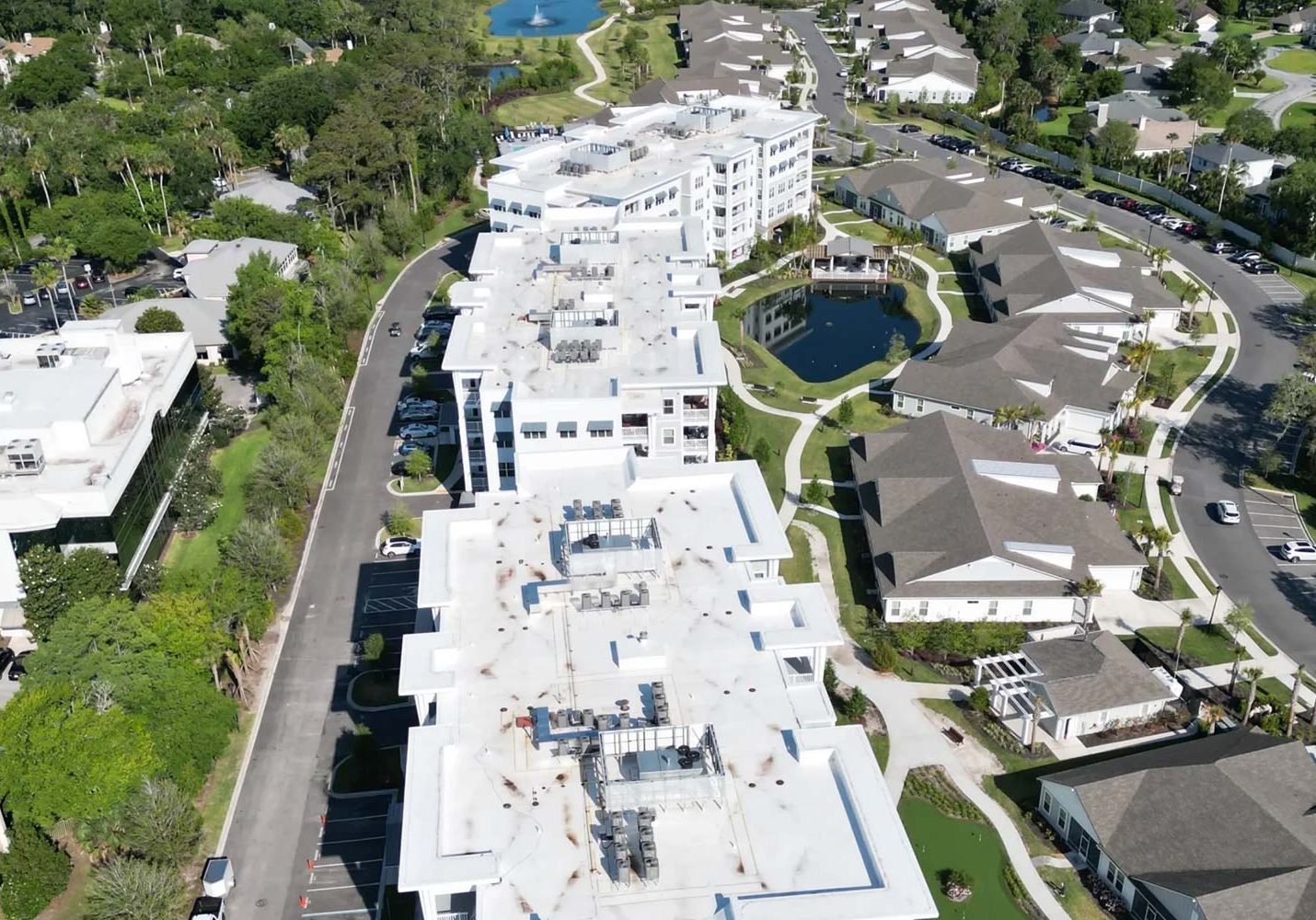 High‑angle shot showing multiple interconnected commercial flat roofs with HVAC systems